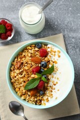 Delicious granola with berries and yogurt on a light background