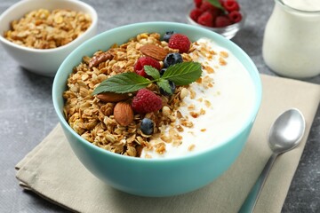 Delicious granola with berries and yogurt on a light background