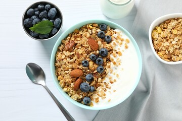 Delicious granola with berries and yogurt on a light background
