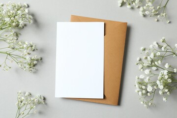 Top view photo with gypsophila flowers and paper card on gray background 