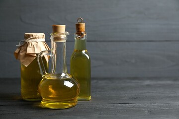 Bottles of fresh olive oil and olives with leaves on white background