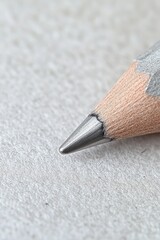 Close-Up View of a Sharpened Graphite Pencil Tip on Paper Surface