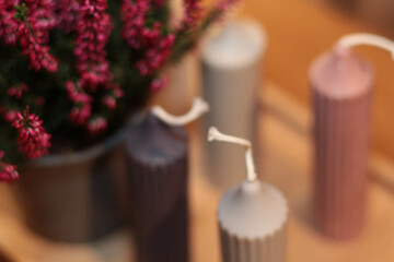 Winter Candle Arrangement. A cozy composition featuring an assortment of colorful candles on a wooden table, complemented by subtle seasonal decorations. Perfect for evoking warmth and festive charm. 