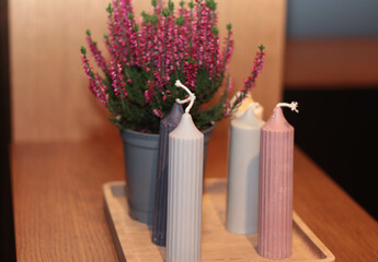 A cozy composition featuring an assortment of colorful candles on a wooden table, complemented by subtle seasonal decorations.