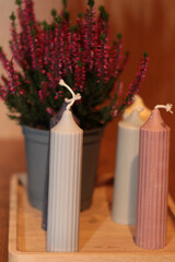 A cozy composition featuring an assortment of colorful candles on a wooden table, complemented by subtle seasonal decorations.