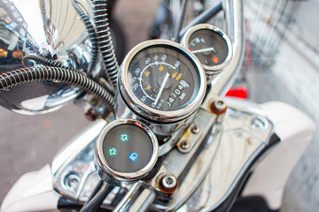 Close-Up of Classic Motorcycle Speedometer and Fuel Gauge with Chrome Detailing, Highlighting Vintage Design and Mechanical Precision in Urban Setting