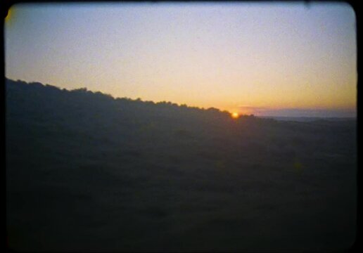 Vintage 16mm film of the sunset over the green valley in the desert, filmed from a car, Las Bardenas, Spain