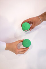 Green macaroons. Sweets. Pink filling for macaroons. Delicious pastries. Hands take macaroons