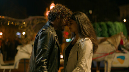 Arabian ethnic couple love dating holding hands touch foreheads cuddling in evening night urban city street travel honeymoon outdoors Indian man woman girlfriend boyfriend affectionate touching heads