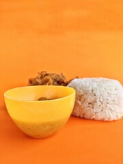fried chicken and white rice with an orange background