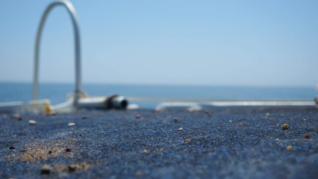 Calm waters stretch endlessly under a clear blue sky. Boat foreground showcases worn details while distant hills create tranquil backdrop. RT Dubovica Rocks near Buljarica, Svetac Rock, Montenegro.