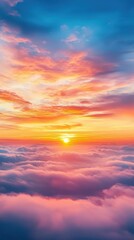 Obraz premium A stunning sunset paints the sky in vibrant hues of orange, pink, and blue, casting a warm glow over fluffy clouds below.