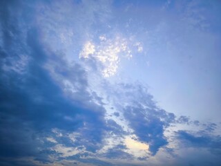 Sunlight, clouds on the background of the morning sky. Blue, white sky in pastel colors, sun glare...