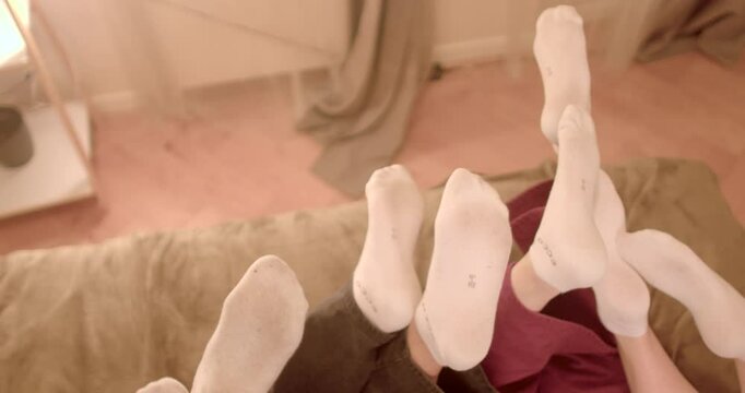 A playful and delightful moment showcasing feet in soft white socks indoors. 6.11.2024 Karlin, Prague, CZ