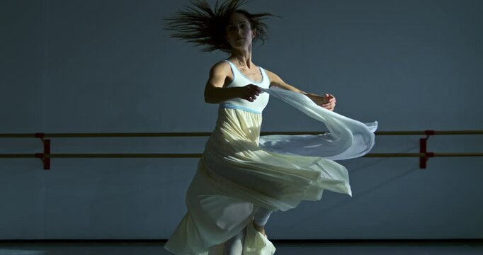 Super slow motion close up of graceful modern contemporary female dancer practices with focus and elegance in dance school or gym, refining her technique and expression through rigorous training 