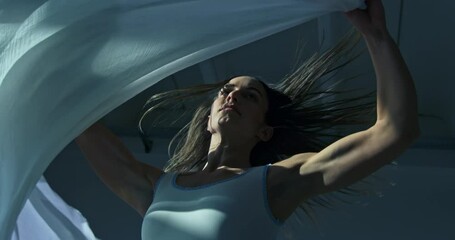 Super slow motion close up of graceful modern contemporary female dancer practices with focus and elegance in dance school or gym, refining her technique and expression through rigorous training 