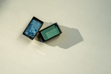 Broken eyeshadow palettes on a white table. Decorative cosmetics