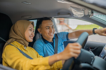 A joyful couple happily sharing a fun and exciting driving experience in an urban setting