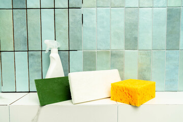 Cleaning tools are arranged on a surface beside epoxy grout and adhesive, ready for tile repair.