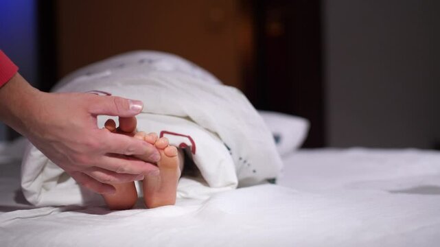 dad wrapped baby in blanket and tickles his legs, feet