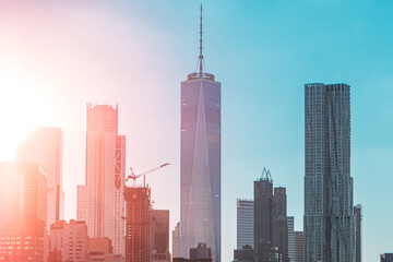 Obraz premium Modern Urban Skyline Featuring Tall Skyscrapers Against a Blue Sky With Sunlight and Architectural Landmarks