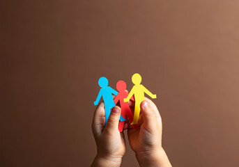 Hands of a Child Holding Colorful Paper Figures Highlighting Autism Awareness, Unity, and Building Safer Communities
