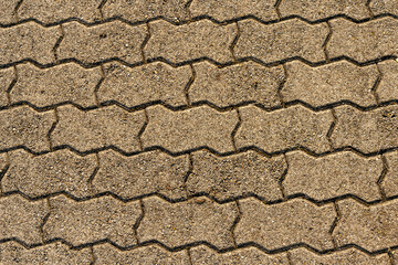 Texture of pavement of a footway, paved with zigzag shaped paving tiles.