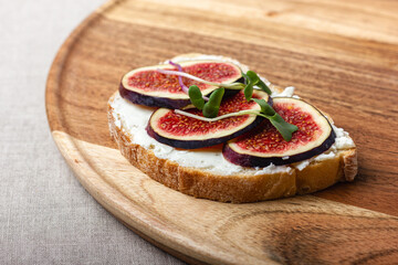 Slices of white bread with young cream cheese, freshly sliced figs and radish sprouts.