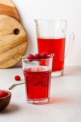 Raspberry drink in the glass on the gray background.