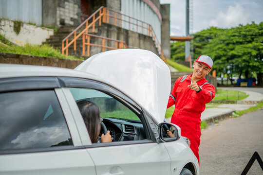 An experienced mechanic helps a stranded driver with car trouble on the roadside