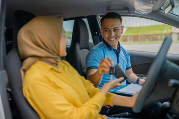 A driving lesson is exchanged between the instructor and student inside the car