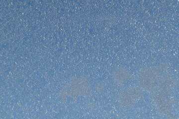 This window glass is frozen in sunny early winter day. 