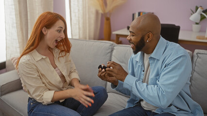 Man proposing to woman on couch showing surprise and joy in living room, highlighting their love and relationship at home