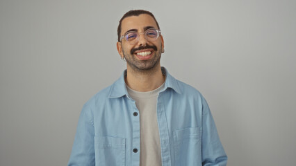 Fototapeta premium Young hispanic man with moustache smiling wearing glasses and blue shirt over isolated white background