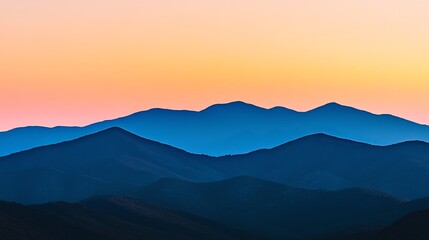 Serene mountain range silhouettes at sunset with vibrant colors.