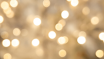 Obraz premium Soft blurred golden and brown bokeh with warm Christmas light reflections.