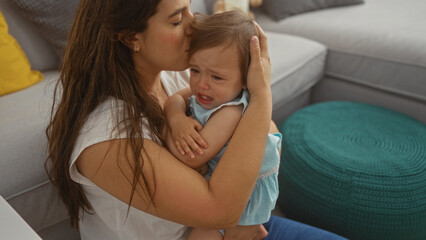 Woman comforting crying toddler girl in living room showing love and affection