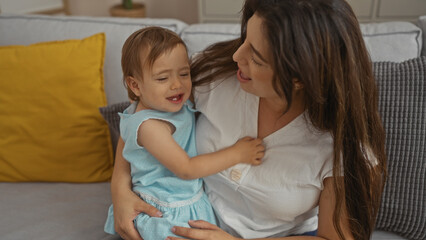 Woman holding toddler daughter indoors in a loving family home setting