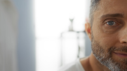 Man relaxing indoors with a calm expression, capturing a peaceful moment in a bright spa...