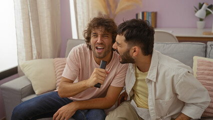 Two men singing together in a living room, enjoying a fun bonding moment as friends or family in a cozy indoor setting.