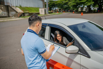 A driving instructor evaluates a student driver while they are undergoing a practical lesson