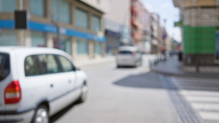 Blurred background of a city street with cars and buildings captured out of focus with bokeh effect in daytime