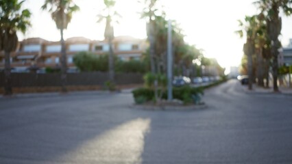 Blurred outdoor street scene featuring palm trees and residential buildings with sunlight creating a defocused, bokeh effect
