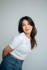 standing half body fashion portrait with hands behind her body with body sideways and natural face looking at the camera with smile, long hair woman