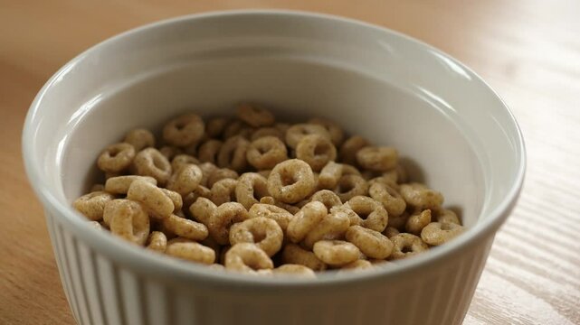 pouring honey cereal circles rings into an empty white bowl