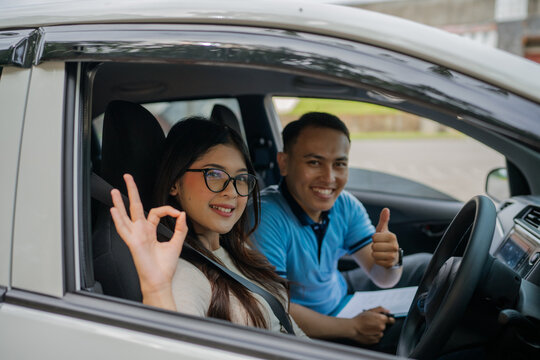A student and instructor celebrate the successful completion of a driving lesson