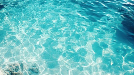 Obraz premium Clear turquoise water with gentle ripples and light reflections.