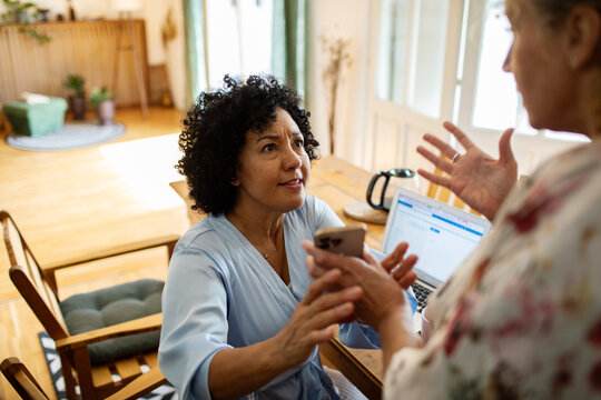 Mature lesbian couple having argument over smartphone