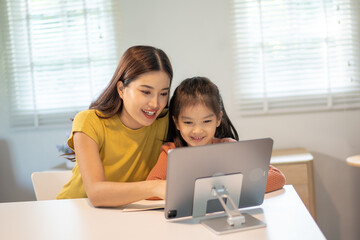 Lovely mom and little young daughter spending time together in their living room.