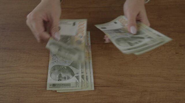 close up of unknown woman hold and count money serbian banknotes